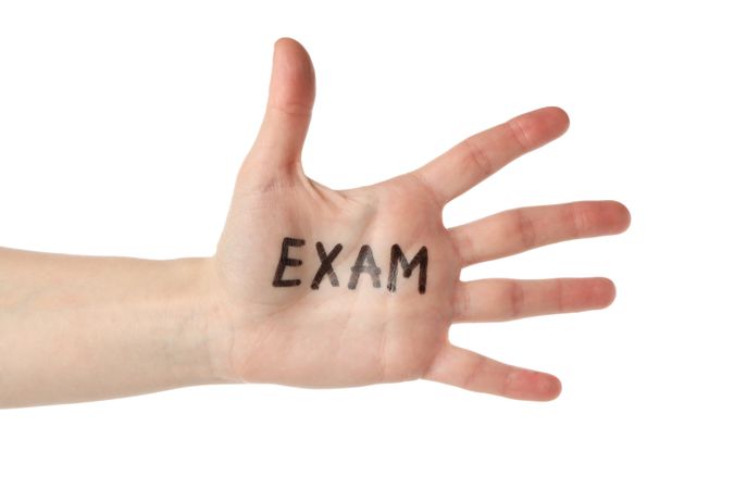 Open hand with the word “exam” written in marker