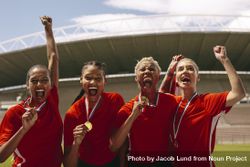 Woman soccer players with medals shouting in joy after winning the championship 5wplL4