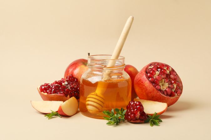 Beige room with honey pot, pomegranate and apple