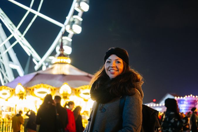 Happy woman on fairground at night