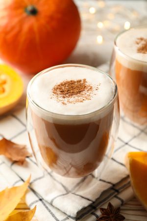 Composition with pumpkin latte on neutral wooden table