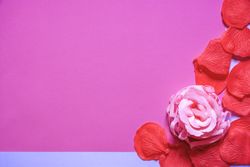 Soap rose and petals on pink paper with copy space