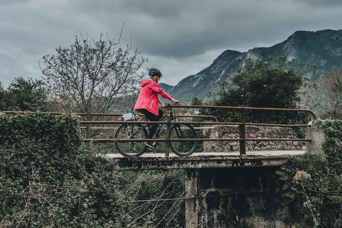 Female riding bicycle on bridge
