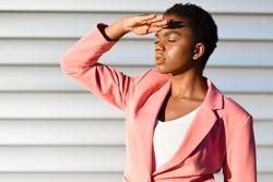 Side view of serious female making salute sign