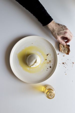 Crop hands with napkin near cheese and condiments