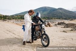 Two people with motorcycle checking directions on phone 5zNLj5