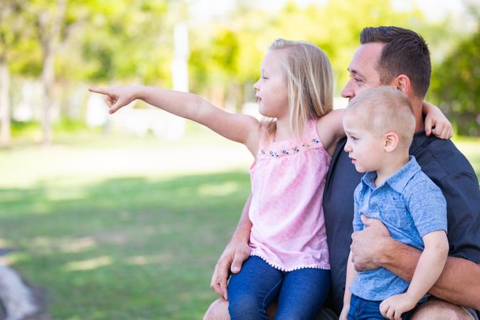 Young Dad, Son and Daughter Having Fun In The Park