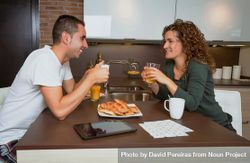Smiling couple chatting over breakfast of pastries and coffee 5qwdJb