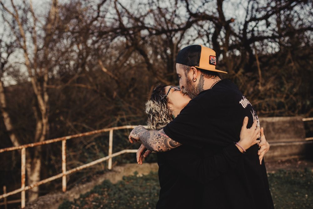 Happy couple hugging near tree in park