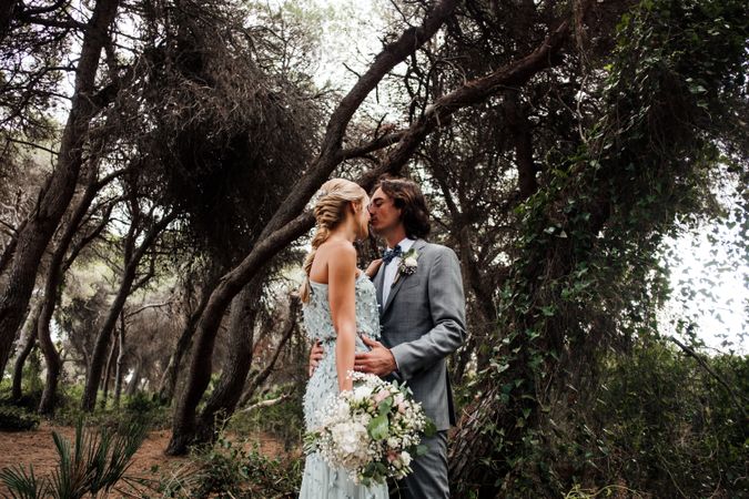 Happy married couple in wedding clothing at forest