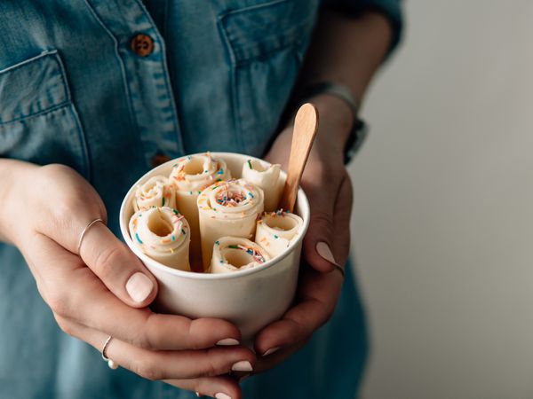 Hand holding rolled ice cream in cone cup