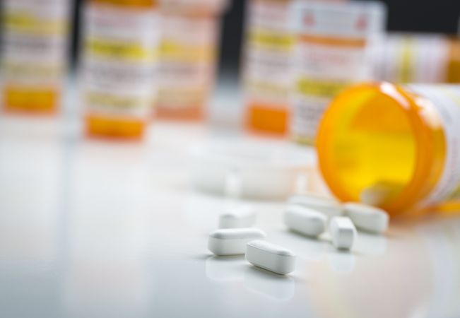 Medicine Bottles Behind Pills Spilling From Fallen Bottle