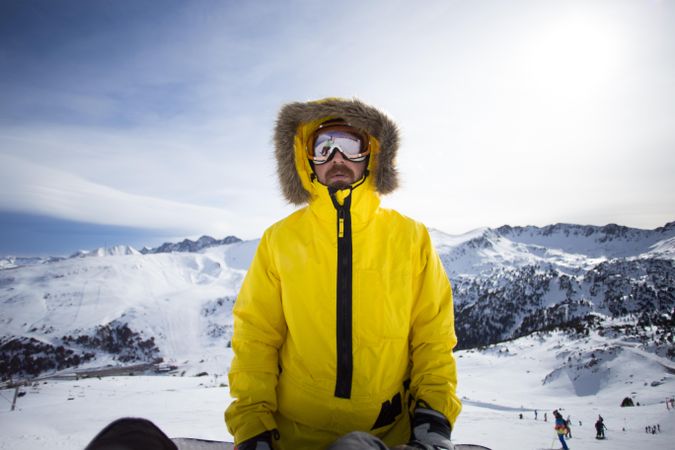 Man in yellow parka and goggles in ski resorts