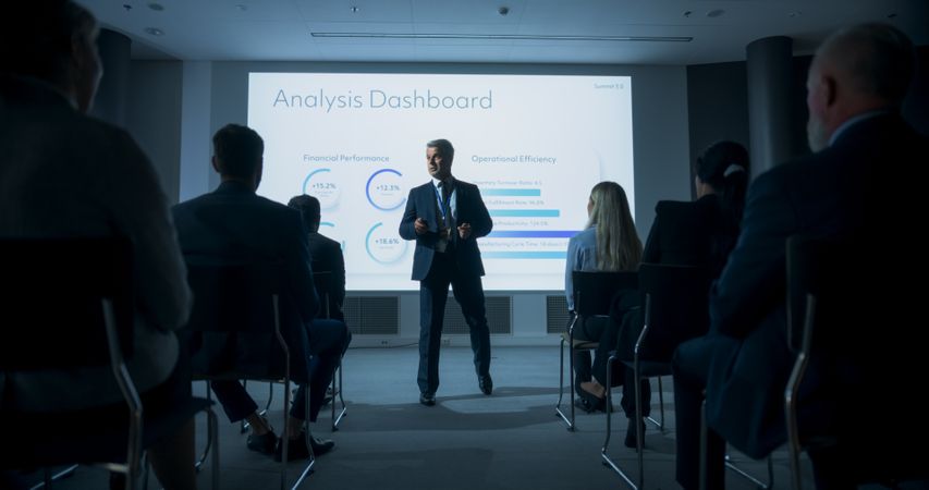 Male Top Manager Walking Between The Rows Of Diverse Audience To Give Presentation At Business Conference.