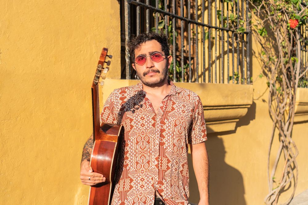 Street musician standing in the street holding his guitar