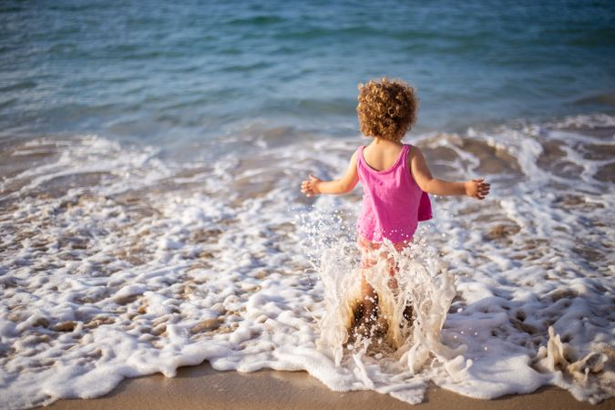 Child going in sea on coast