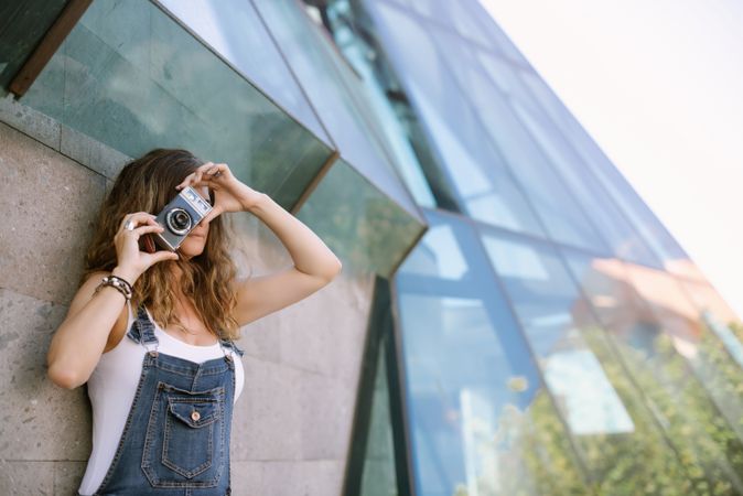Creative woman taking photo on camera in sunny day