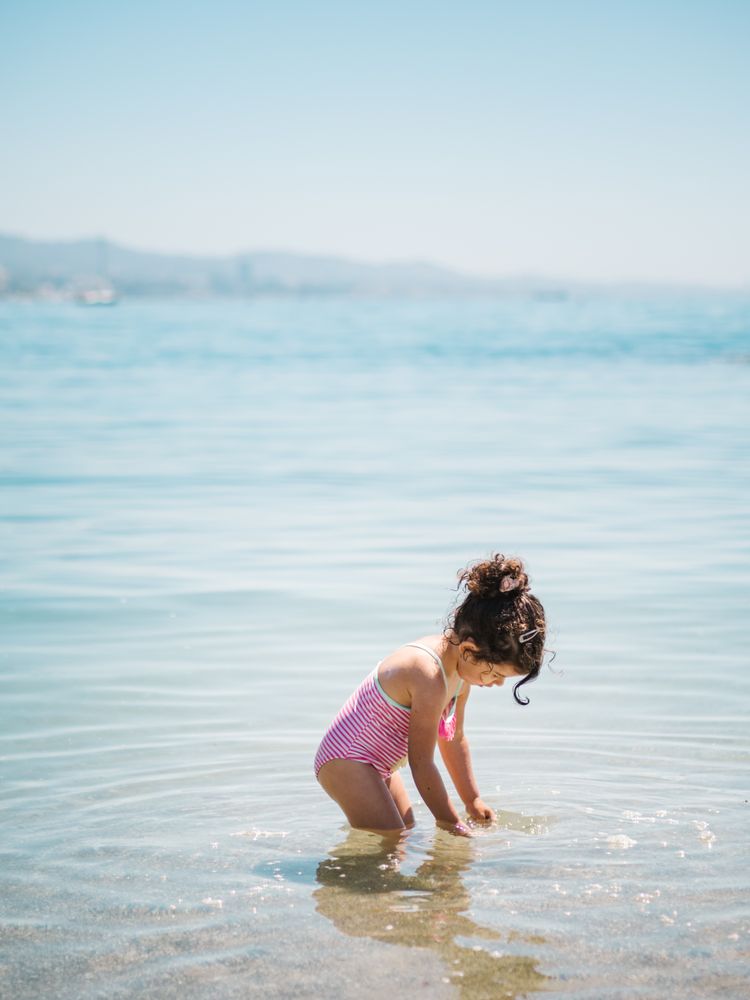 Cute girl playing in water of seaside