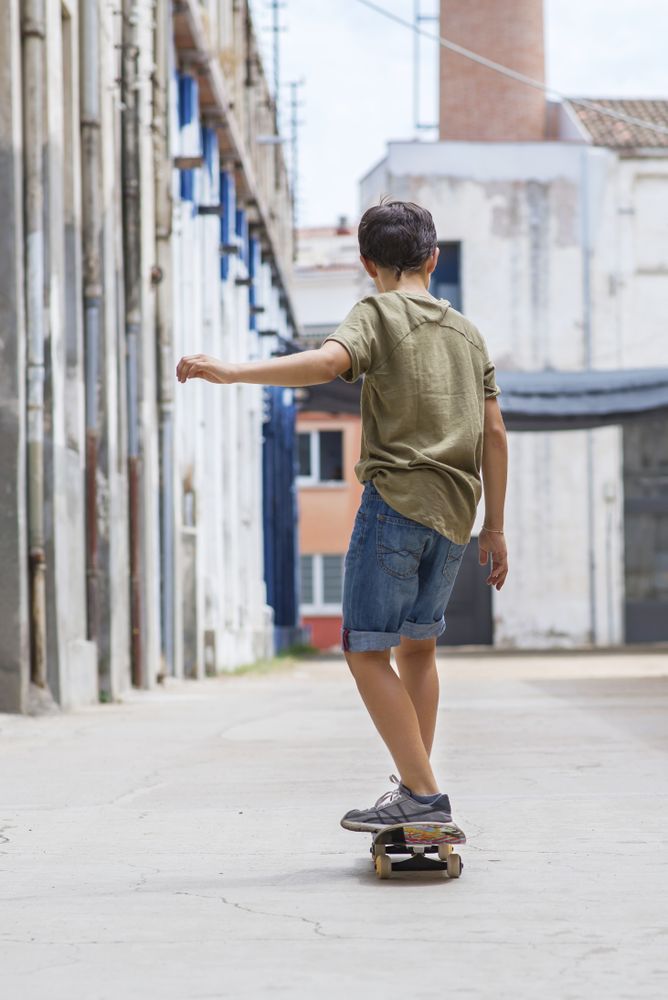 Back of a skateboarder riding on the street