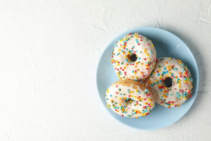 Plate with tasty donuts on plain background