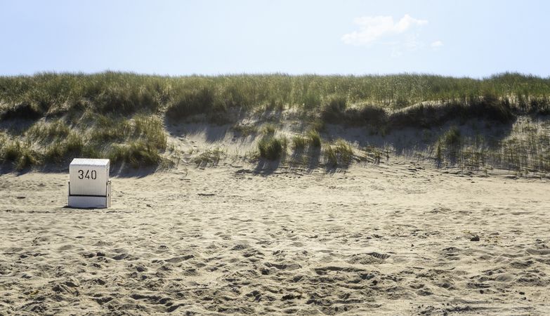 Beach scenery with a single wicker chair in the morning light