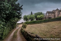 Path next to field in French village on overcast day 0P9VN5