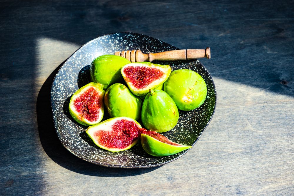 Top view of fresh figs on plate in sunny kitchen