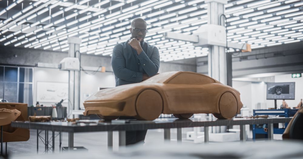 Portrait of Automotive Designer Developing a 3D Clay Model of a New Production Car.