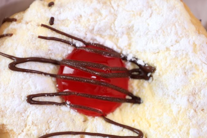 Donut with Powdered Sugar, Strawberry Jam, and Chocolate Sauce