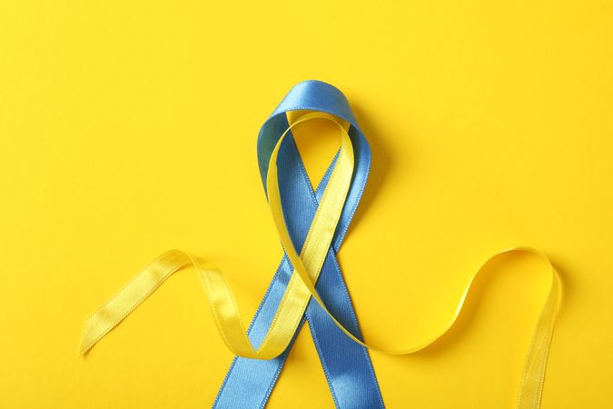 Ribbon in Ukrainian flag colors on yellow background