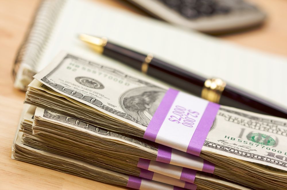 Stack of Money, Calculator, Paper and Pen