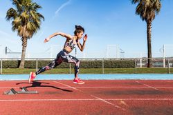 Athletic woman running on stadium