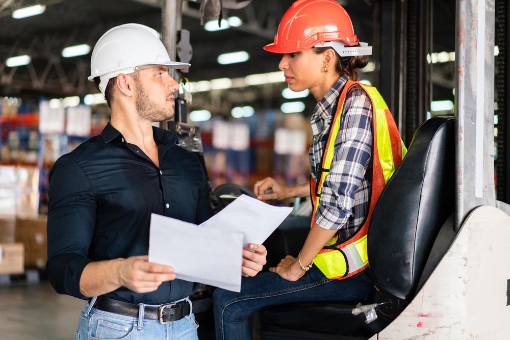 Two colleagues reading itemized list in distribution center