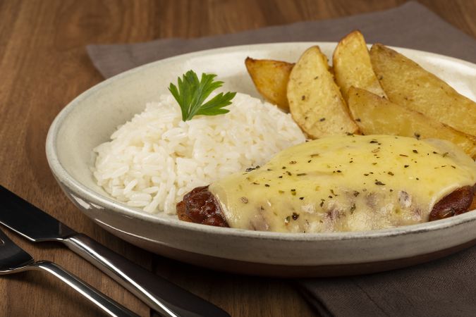 Parmigiana steak with rice and roasted potatoes. Typical Brazilian dish.