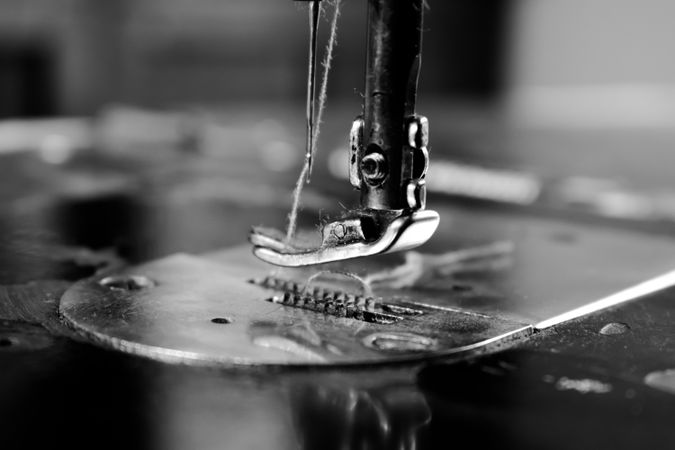 Close up of sewing machine needle and string