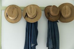 Men's straw hats, hanging inside the farmhouse at Yoder's Amish Home, Walnut Creek, Ohio R5RmB0