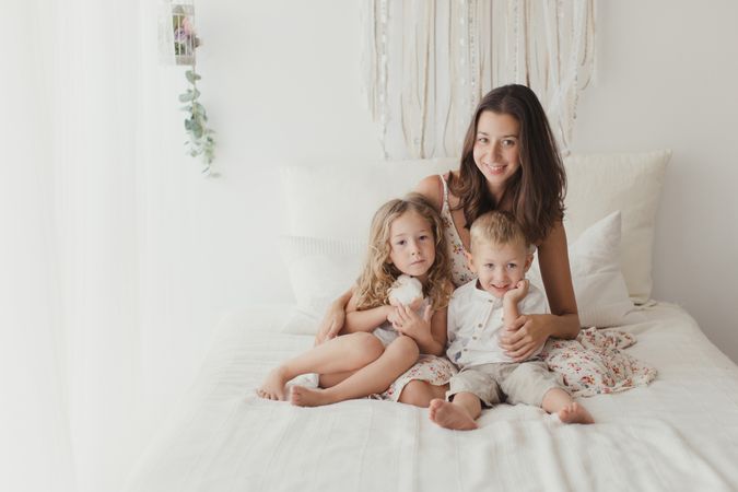 Content young mother with little kids at bedroom