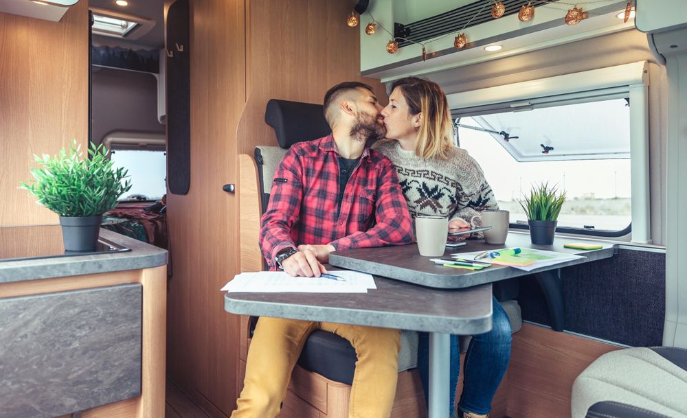 Affectionate male and female couple working in back of van