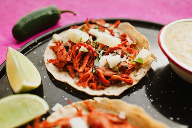 Pepper and lime near tacos al pastor and sauces