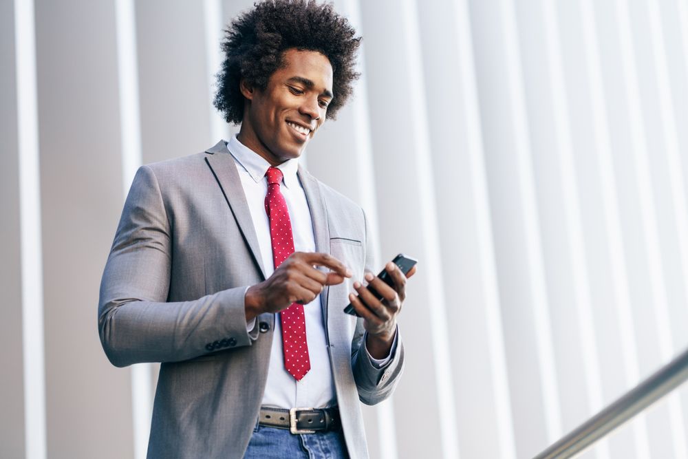 Happy man texting on his phone