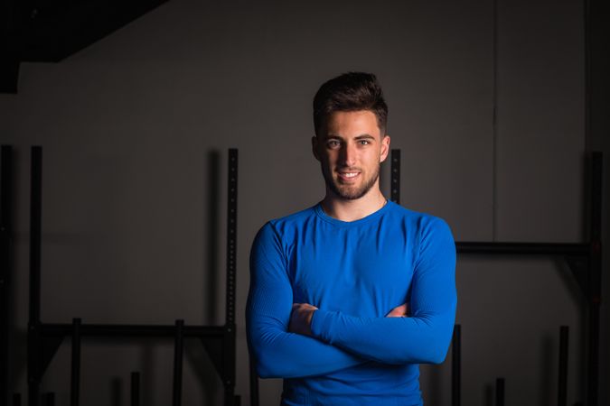Smiling man with crossed hands in gym