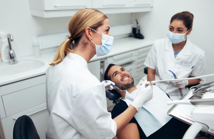 Dental doctor looking at a display monitor while treating a male patient