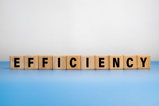 efficiency word text on wooden blocks on blue blue background