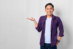 Asian male in grey studio presenting something