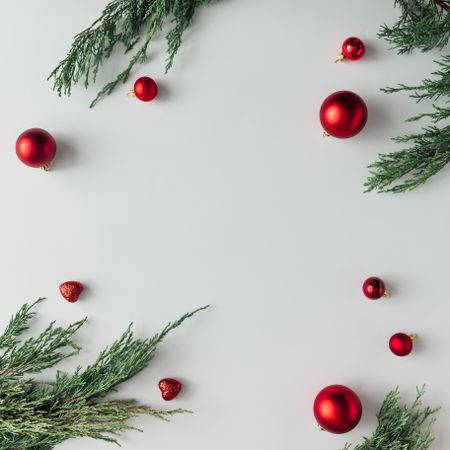 Christmas layout made of branches and baubles on light background