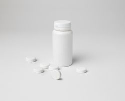 Mockup of a closed aspirin bottle, small size, on background with copyspace