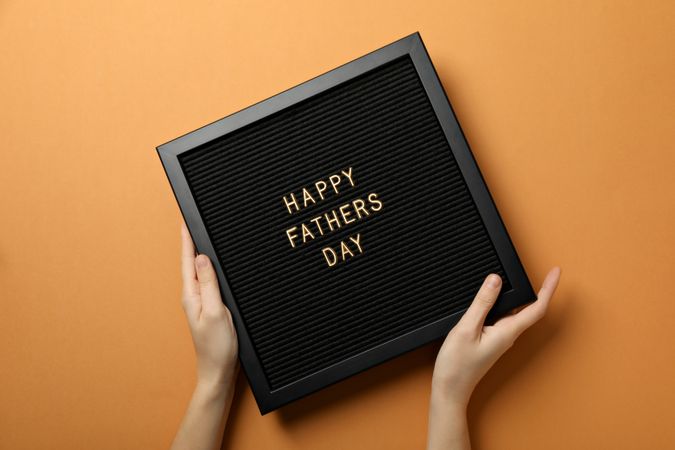 Inscription on a board for Father's Day, on an orange background.