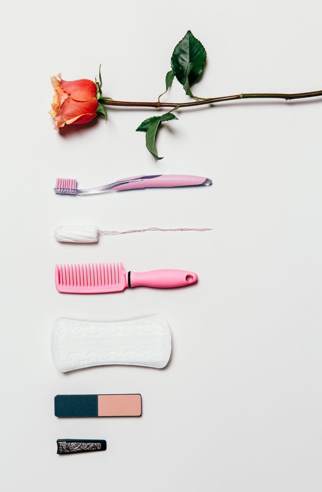 Feminine accessories in pink tones over plain background