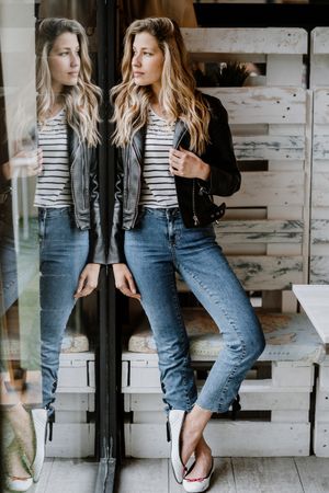 Casual stylish woman standing at table in cafe