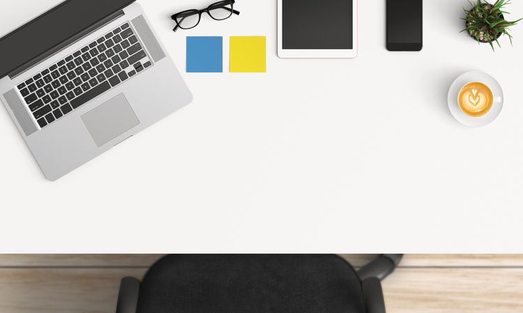 Modern workplace with laptop, coffee cup and smartphone or tablet copy space on table background. Top view. Flat lay style.